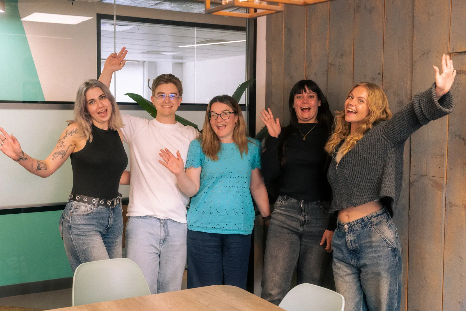 Exposure Marketing team waving together in the office.
