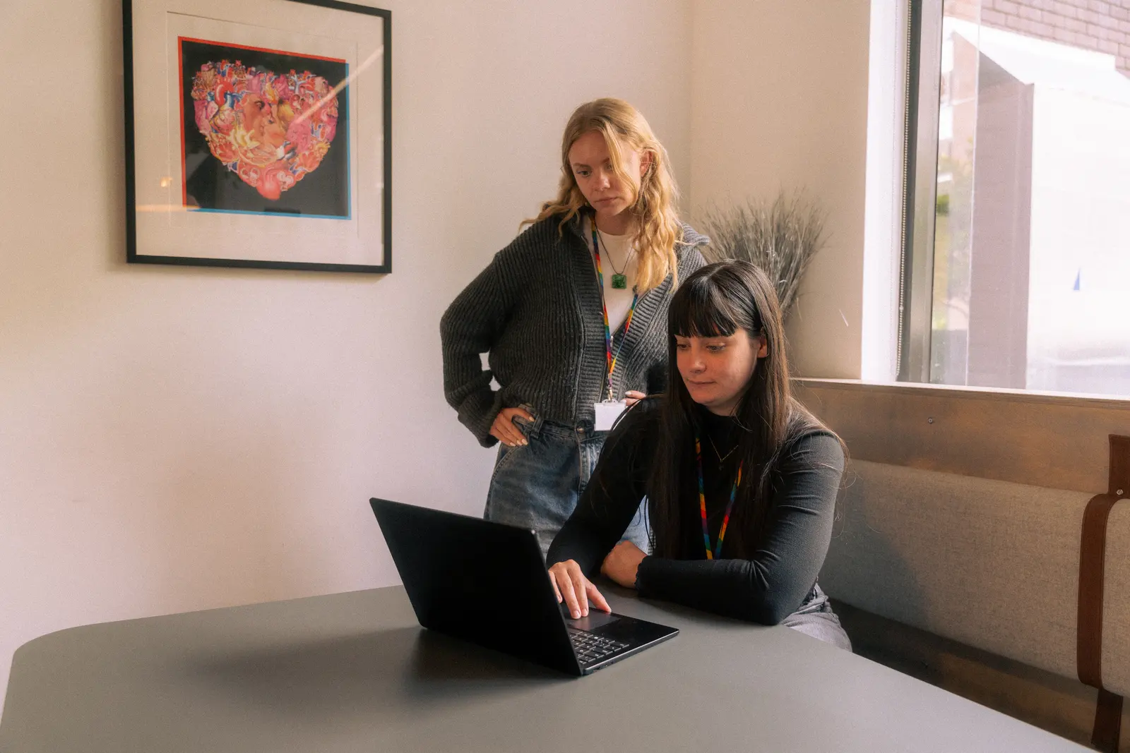 Two Exposure Marketing team members reviewing laptop work in the office.