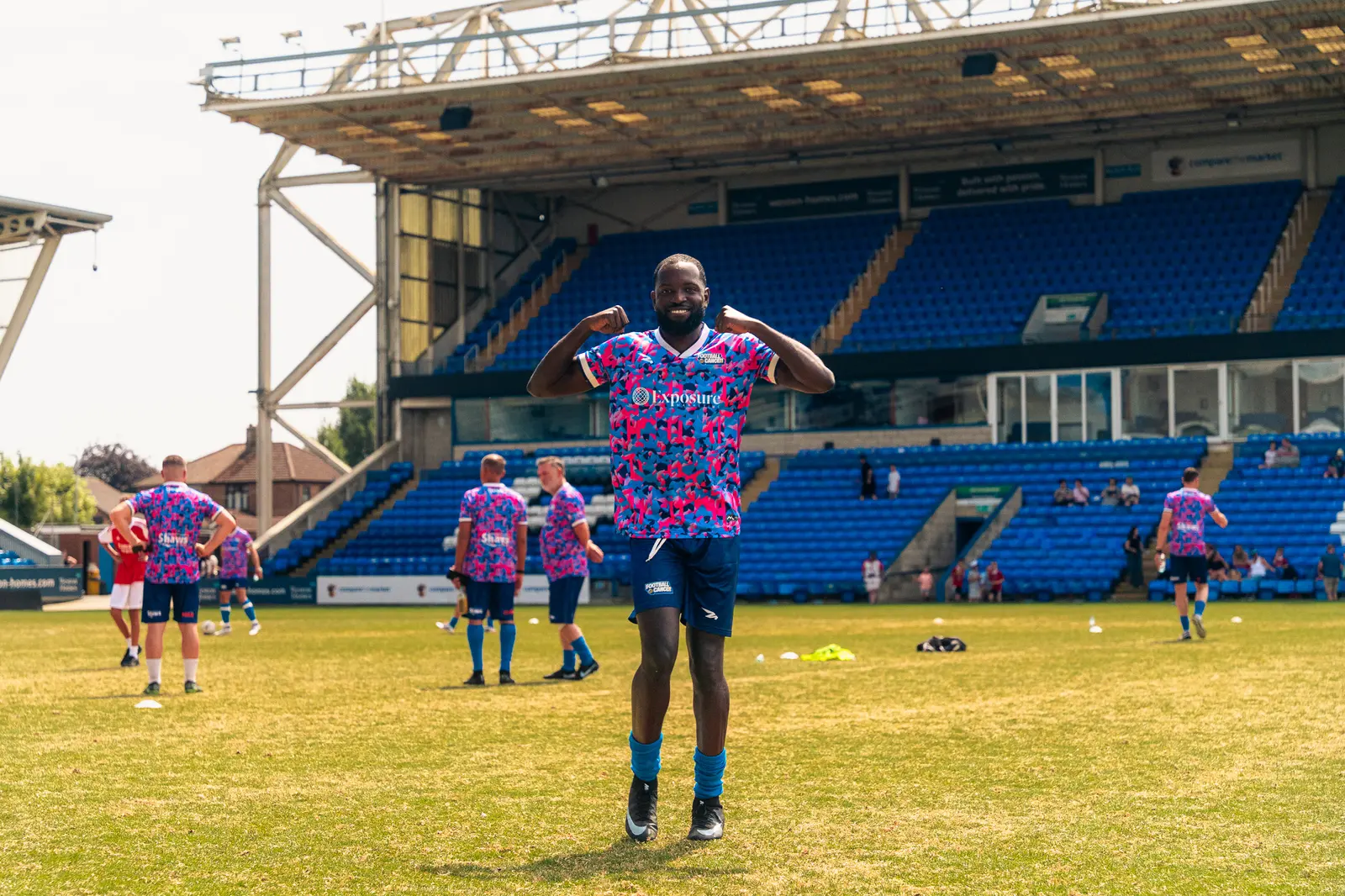 Football Vs. Cancer player in a pink kit on the pitch.