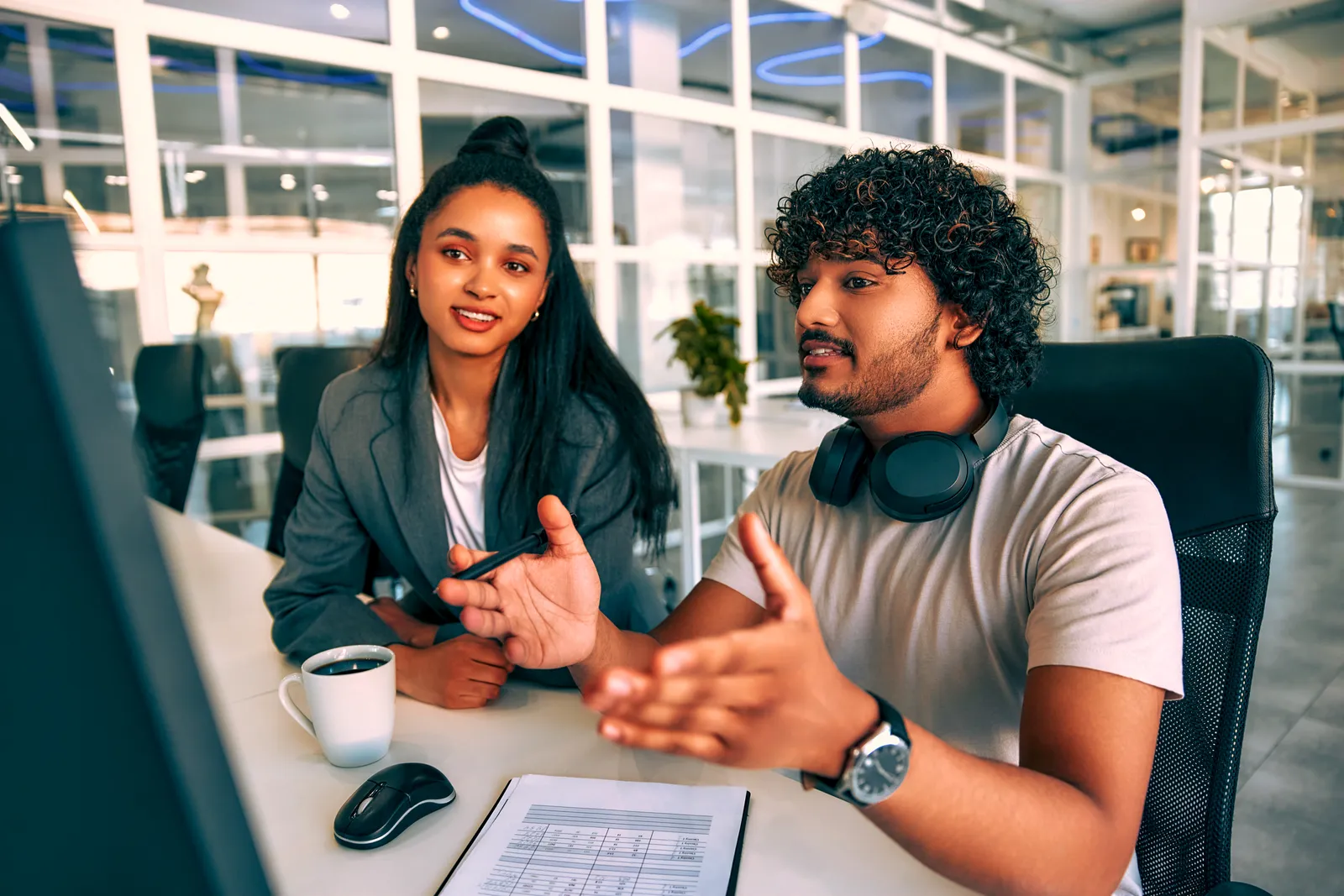 Business partners collaborating at a computer in a modern office.