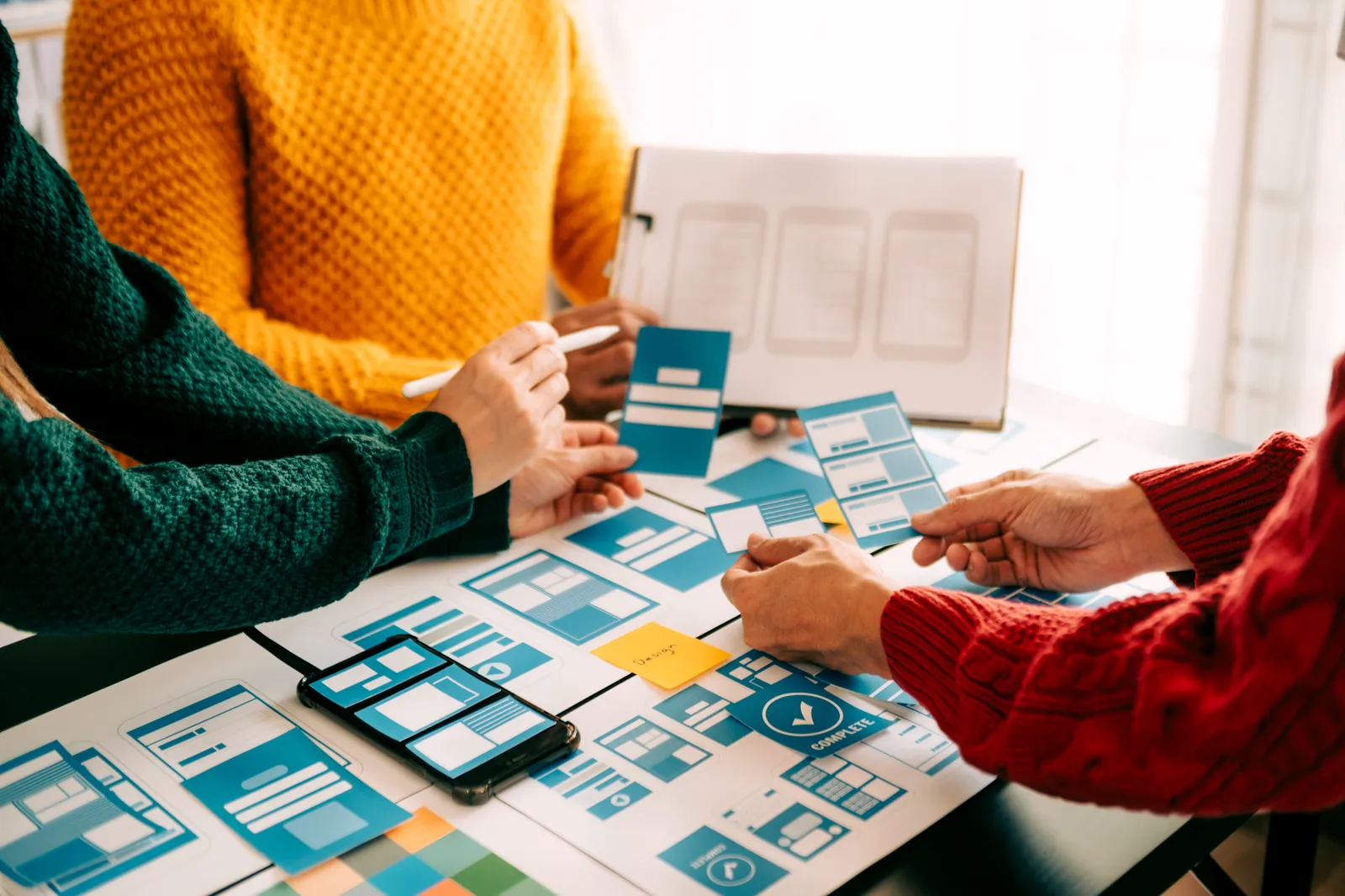 A UI team reviewing a digital product interface on a laptop.