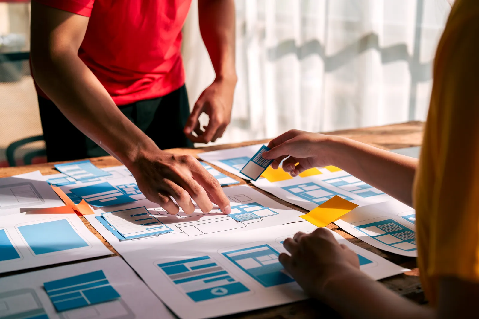 Designers planning interface ideas together in a workspace.