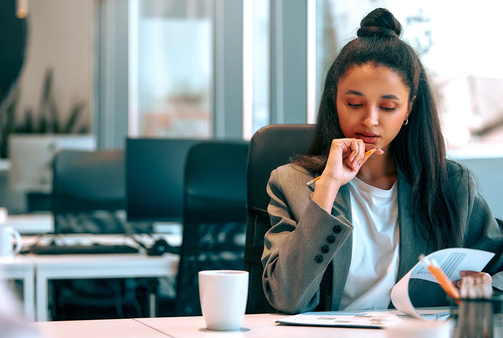 A business owner reviewing paperwork beside a laptop.