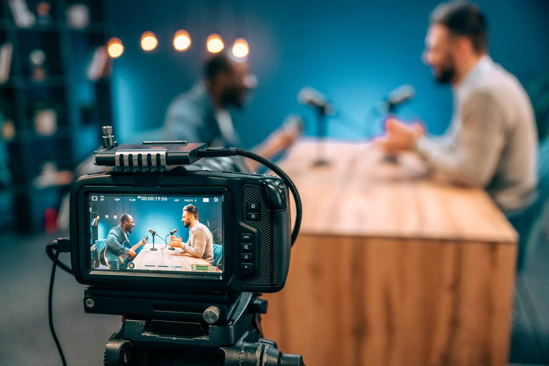 Radio presenters recording an interview in a studio.